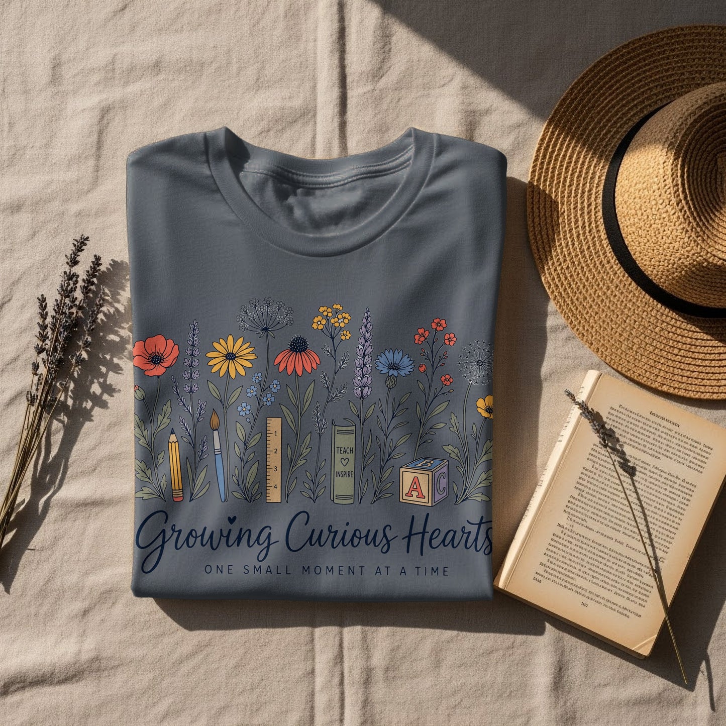 Gray t-shirt with colorful floral design and text "Growing Curious Hearts".