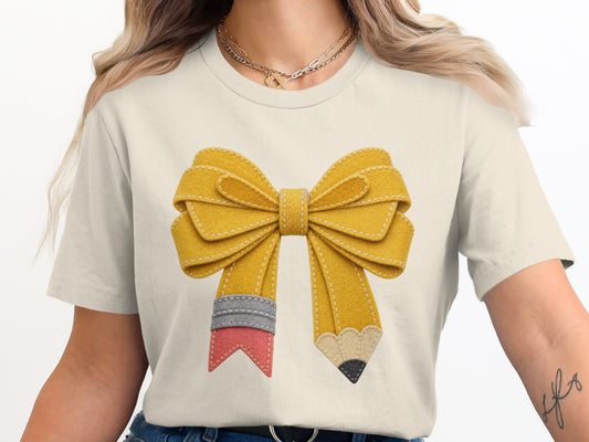 Yellow felt bow graphic on cream t-shirt in a pencil design.