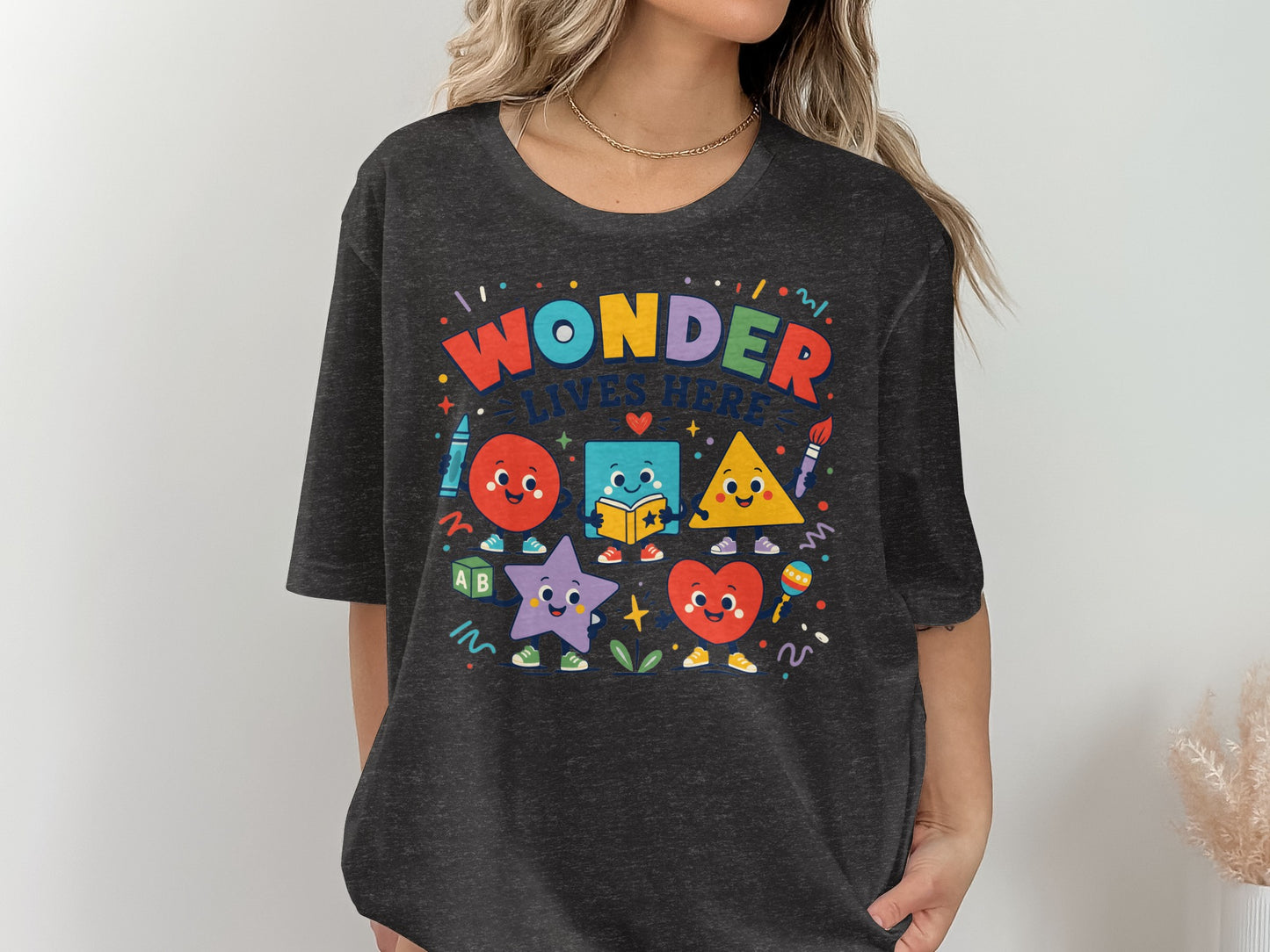 T-shirt with "Wonder Lives Here" and cartoon shapes.