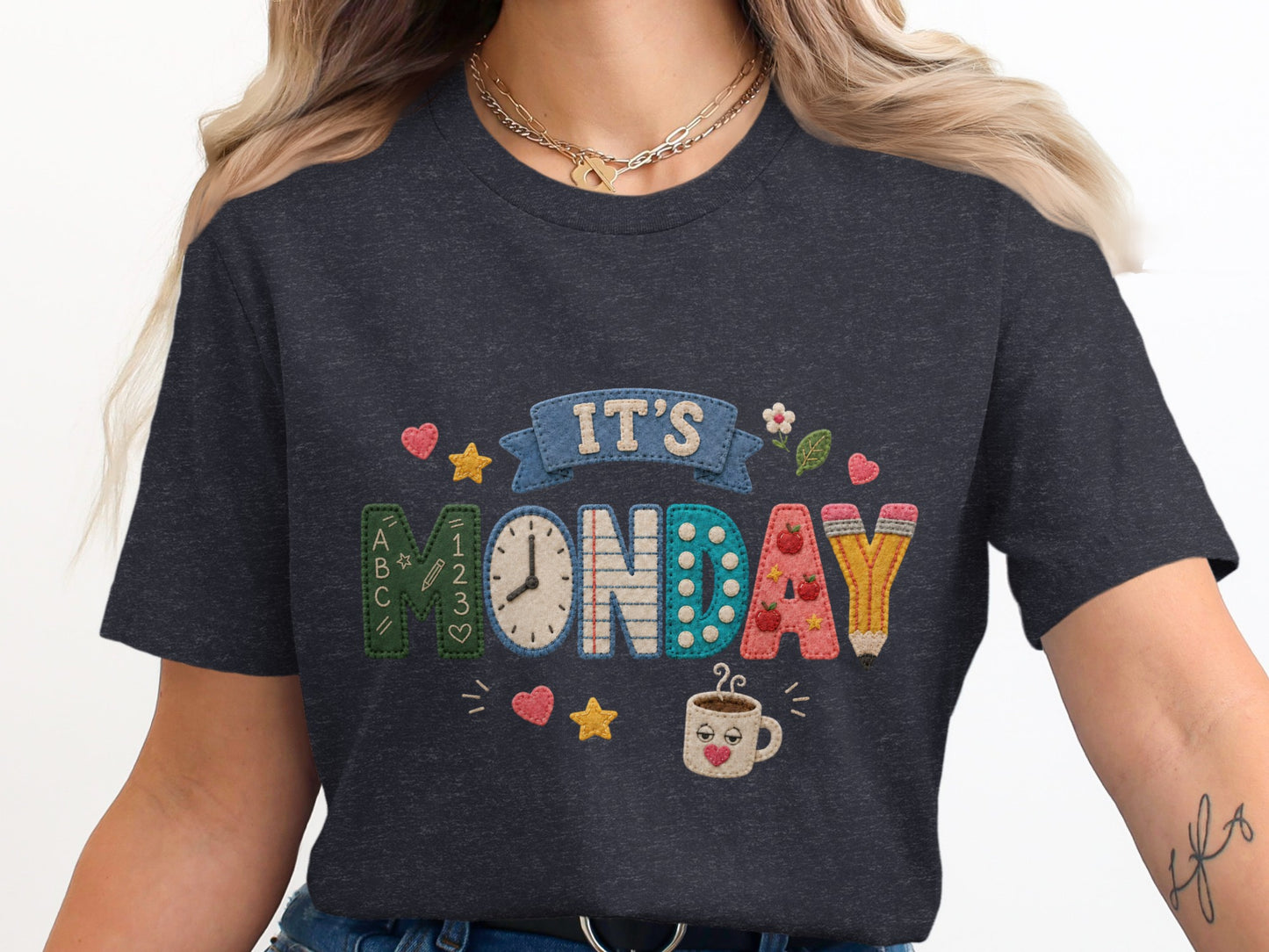 Dark grey t-shirt with embroidered "IT'S MONDAY" design featuring school elements.