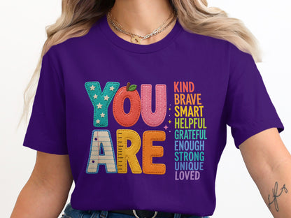 Purple t-shirt with "YOU ARE" and inspirational words like KIND, BRAVE, SMART.