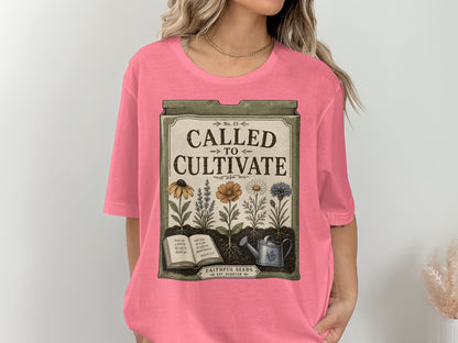Pink t-shirt with "Called to Cultivate" design featuring flowers, book, and watering can.