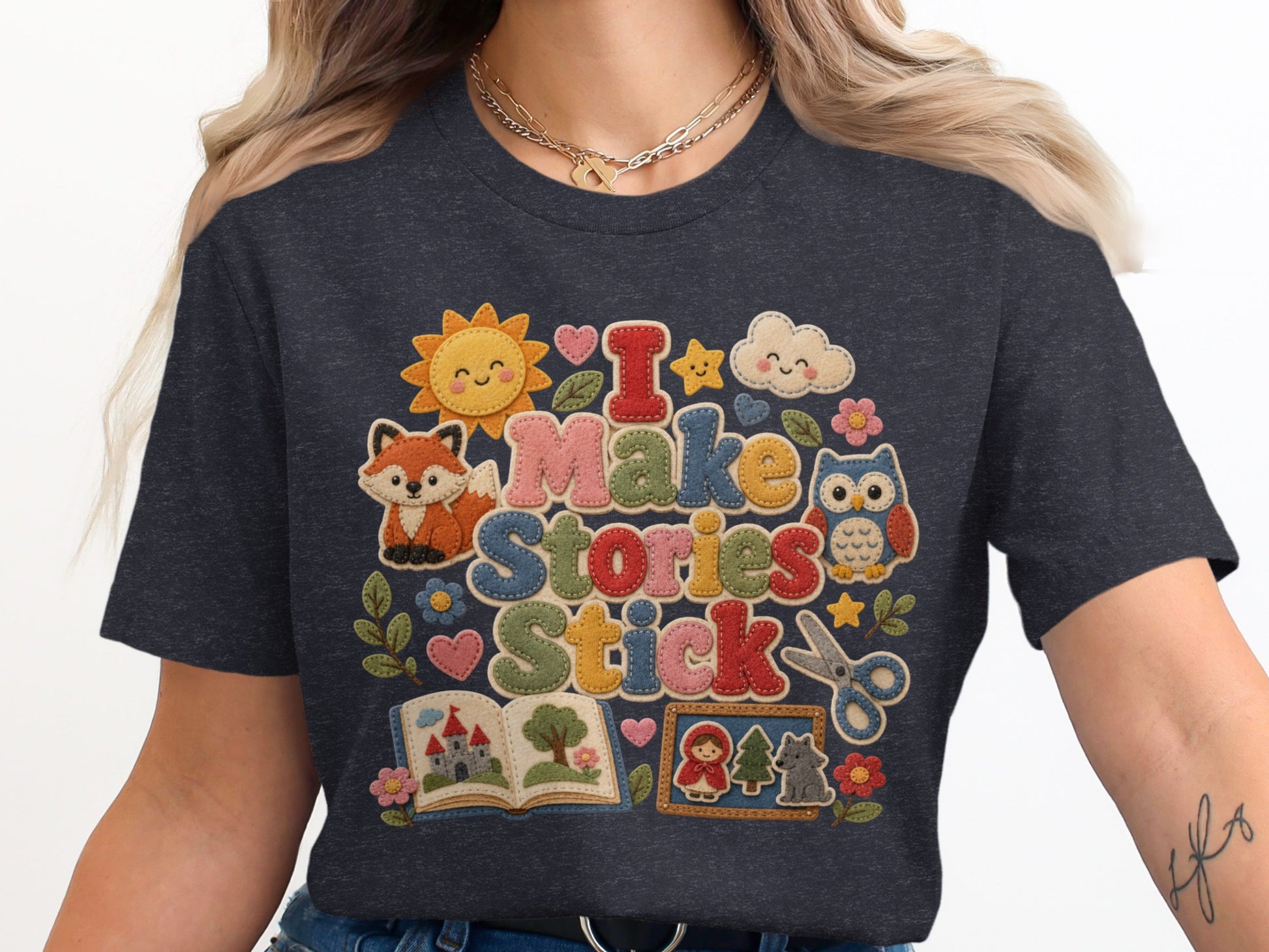 Dark t-shirt with "I Make Stories Stick" text and embroidered characters.