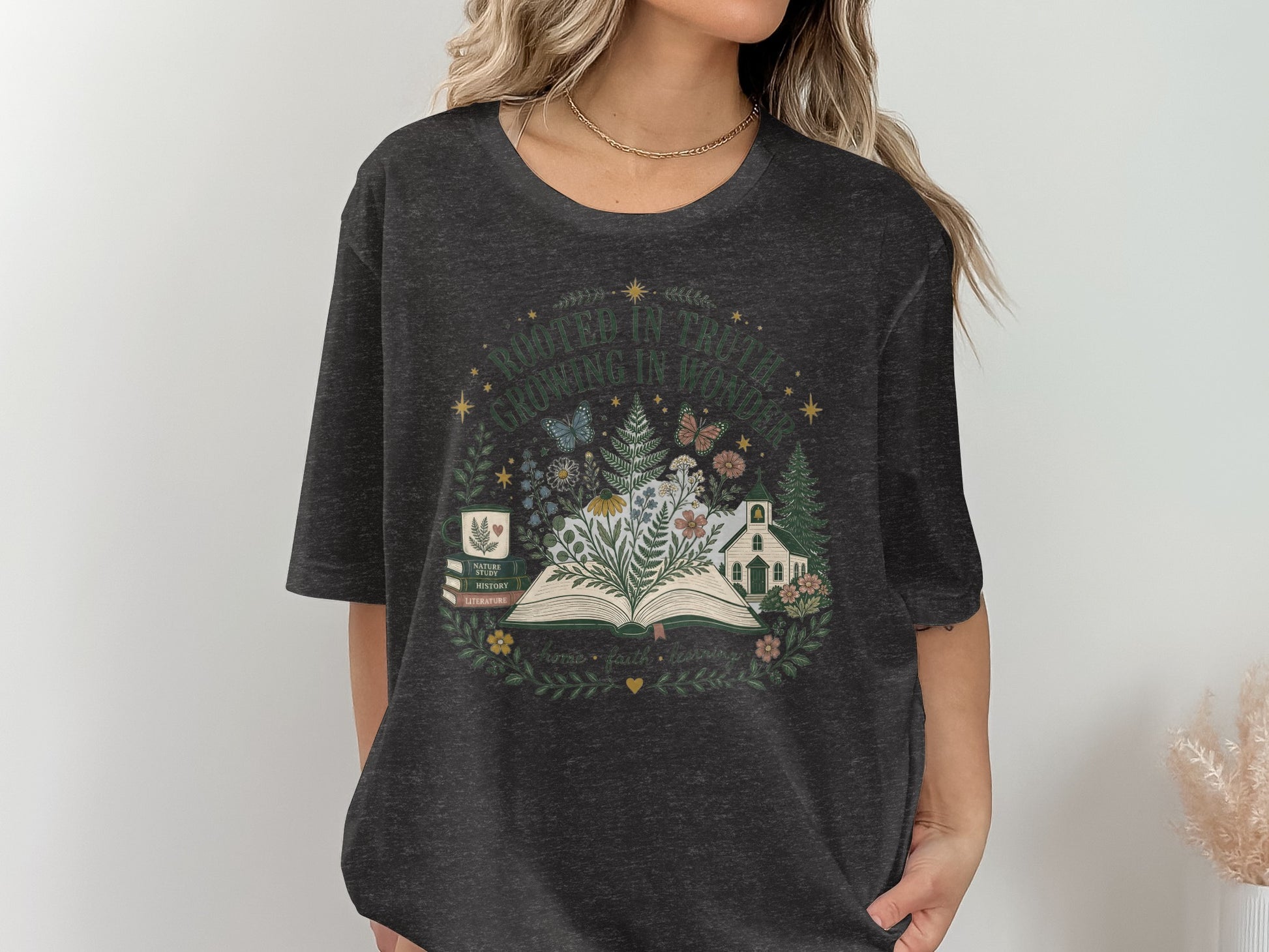 T-shirt graphic with open book, nature, church, and text "Rooted in Truth".