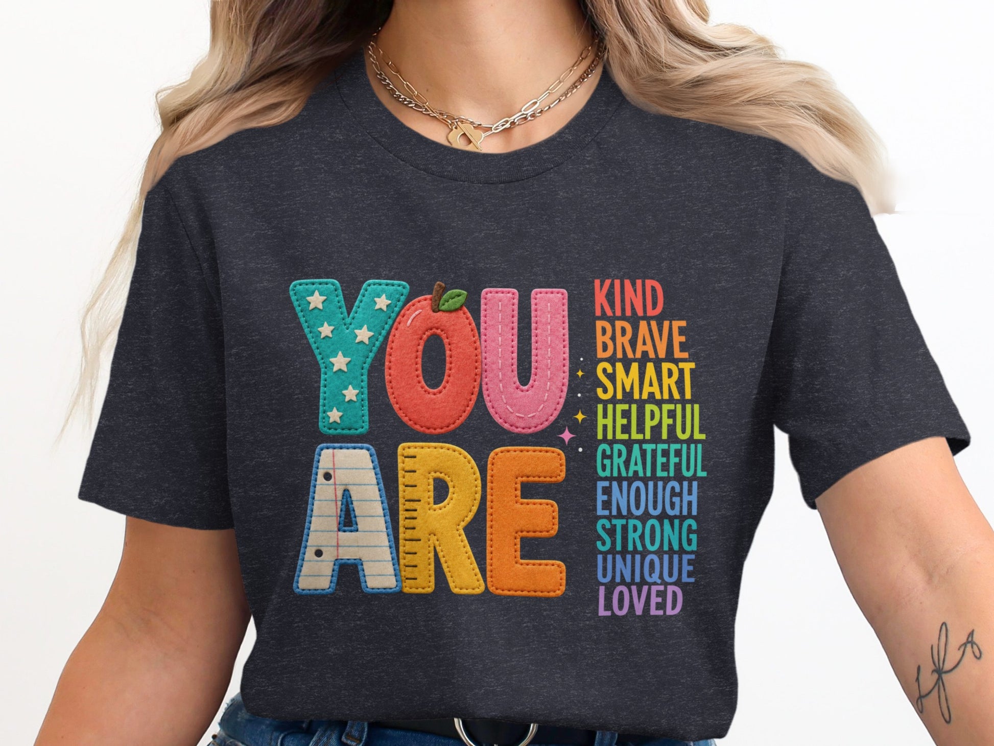 "YOU ARE" text with positive affirmations in rainbow colors on a charcoal t-shirt.