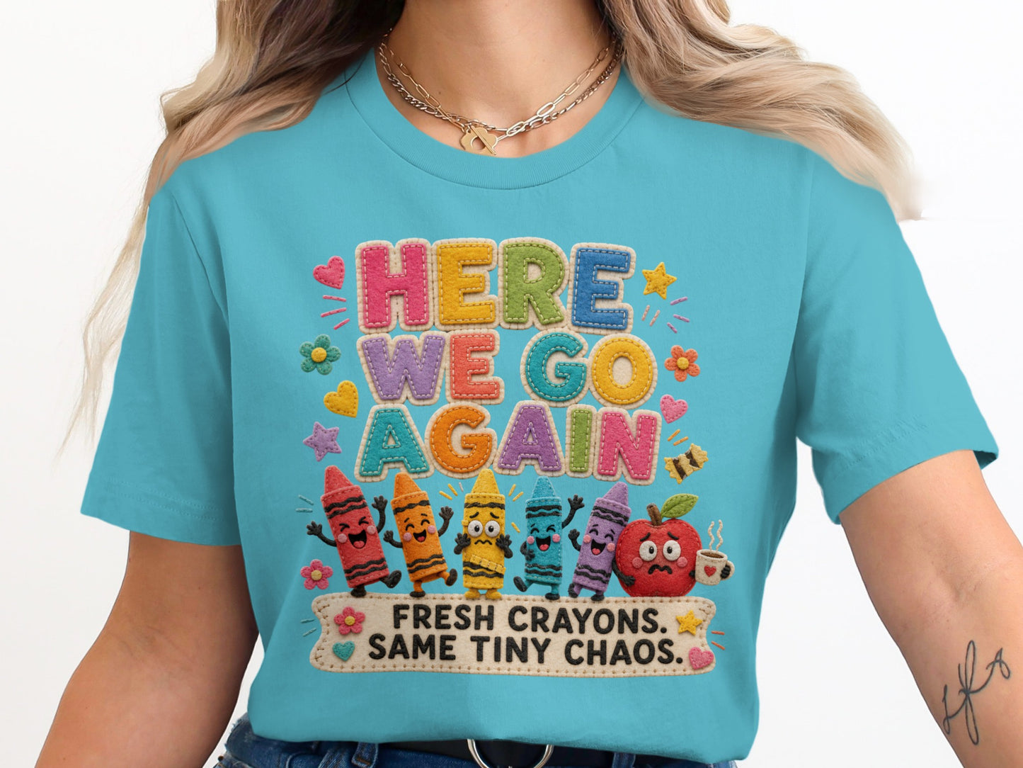 T-shirt with "HERE WE GO AGAIN FRESH CRAYONS. SAME TINY CHAOS." text and cartoon crayons.