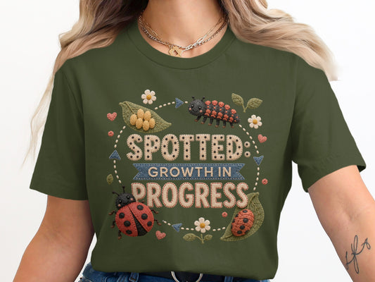 Green t-shirt with "SPOTTED GROWTH IN PROGRESS" and ladybugs.