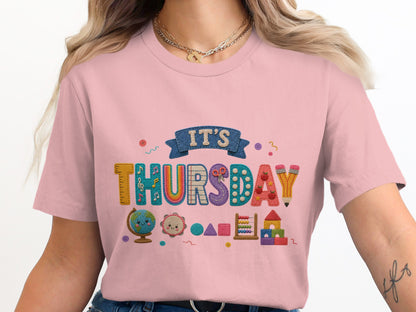 Pink t-shirt with "IT'S THURSDAY" graphic featuring school supplies and cute icons.