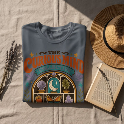 T-shirt with "The Curious Mind Collective" text and celestial, natural imagery.