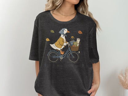 Duck on a bicycle with a basket of books, text reads "OFF TO FIND ANOTHER STORY."