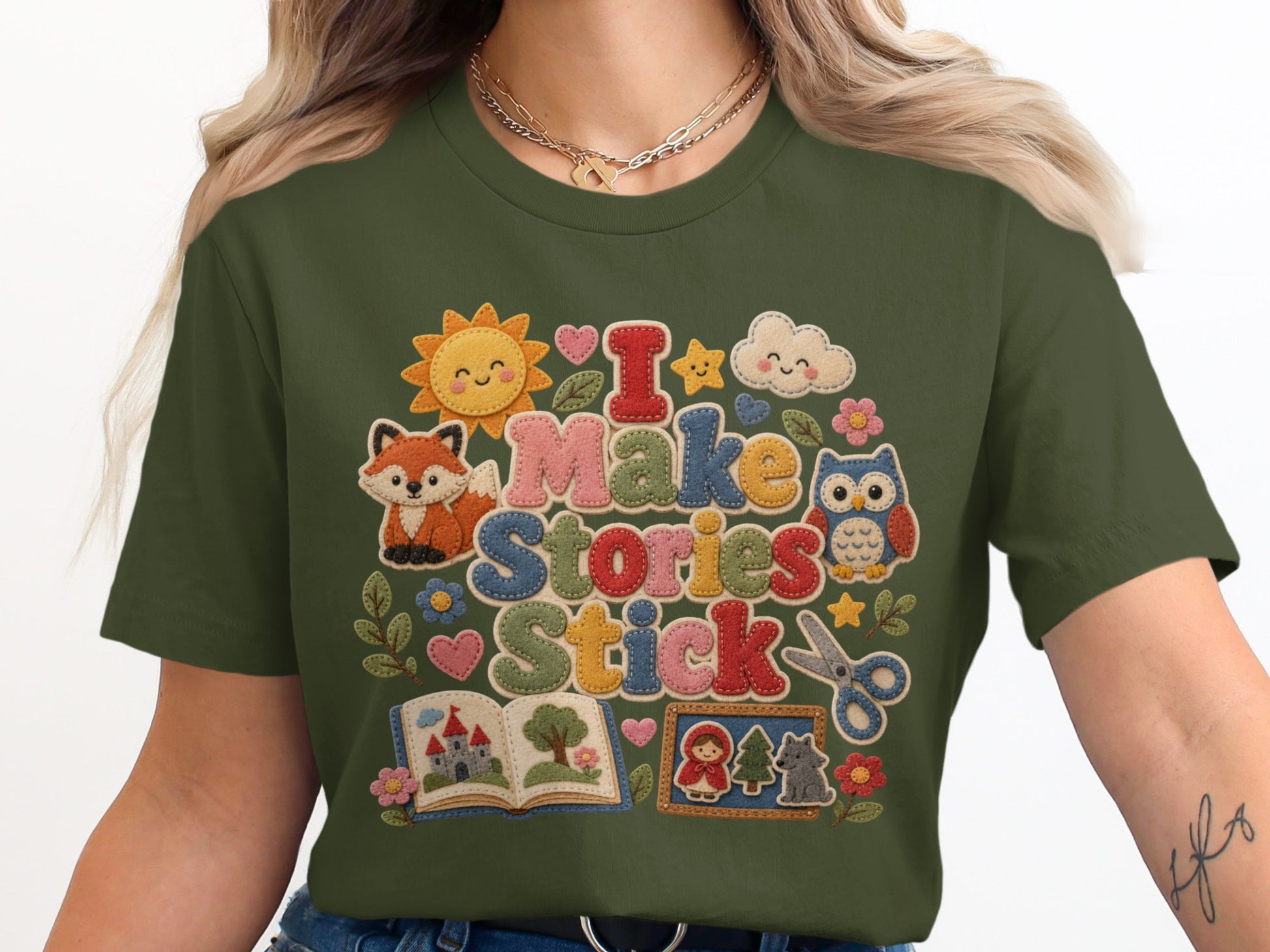 Green t-shirt with "I Make Stories Stick" graphic in colorful felt-like letters.