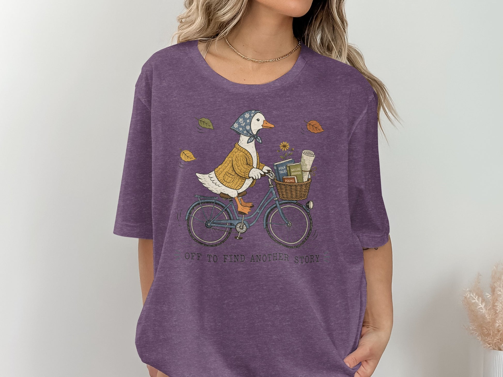 Duck in a sweater and scarf riding a bicycle with books in the basket.