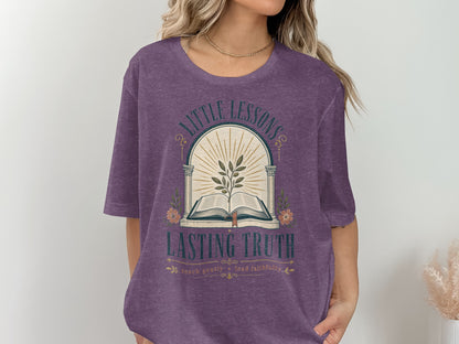 Purple t-shirt with "Little Lessons Lasting Truth" and open book graphic.