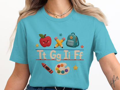 T-shirt with embroidered apple, pencils, backpack, crayon, and letters Tt Gg Ii Ff.