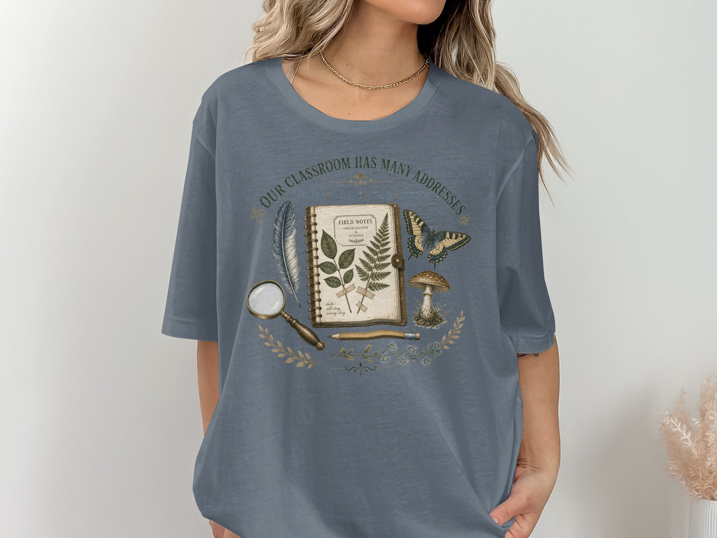 T-shirt with "Our classroom has many addresses" text and natural history illustrations.