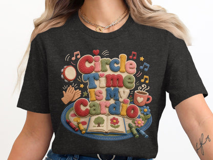 Dark t-shirt graphic with textured letters saying "Circle Time Is My Cardio," featuring art supplies and music notes.