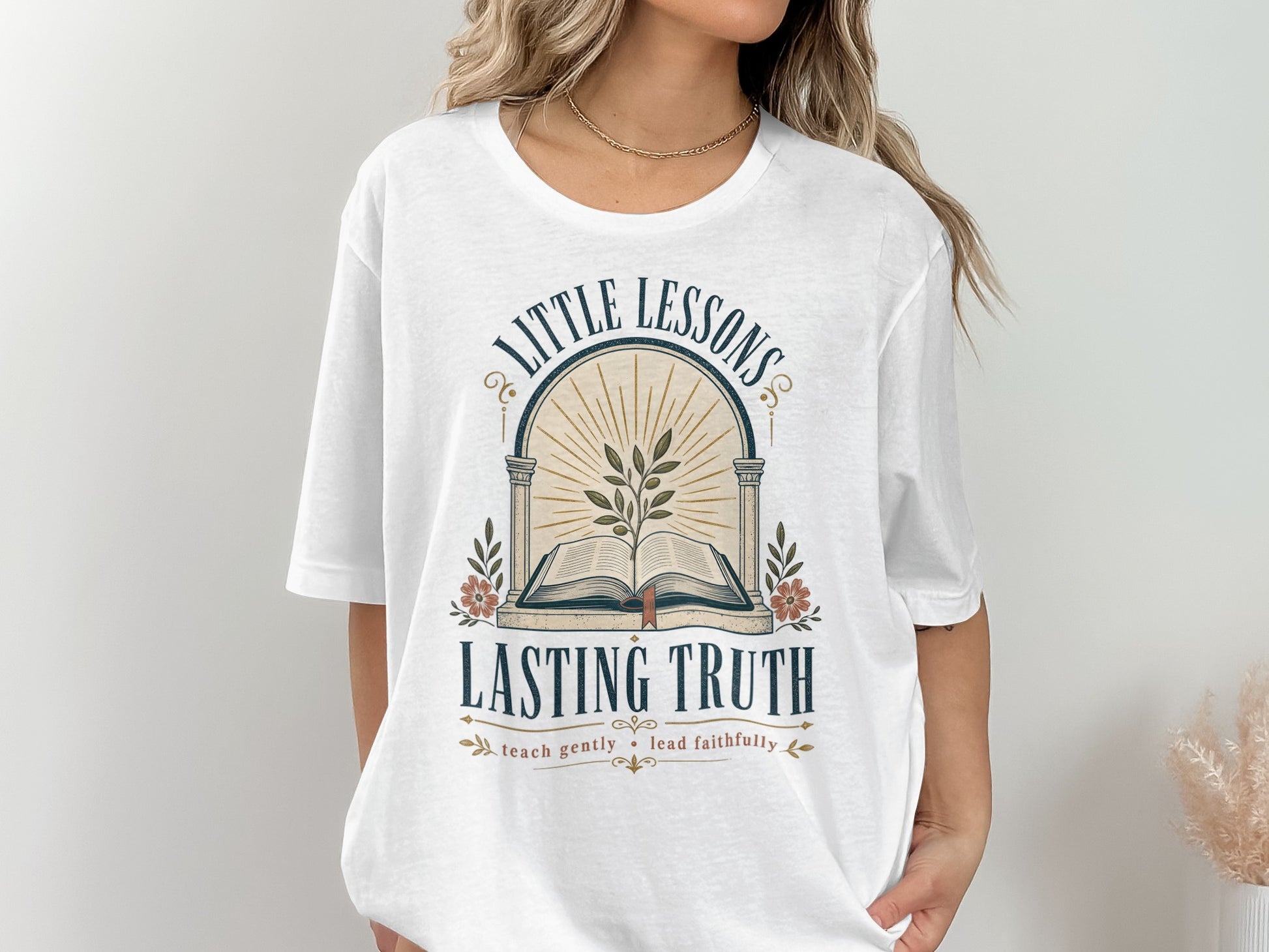 White t-shirt with "Little Lessons Lasting Truth" graphic and plant design.