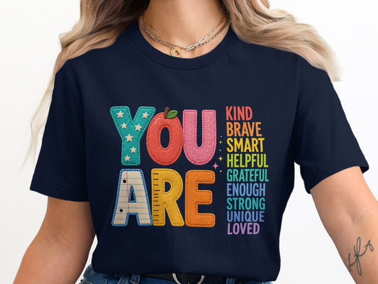 Navy t-shirt with "YOU ARE" and inspirational words like KIND, BRAVE, SMART.