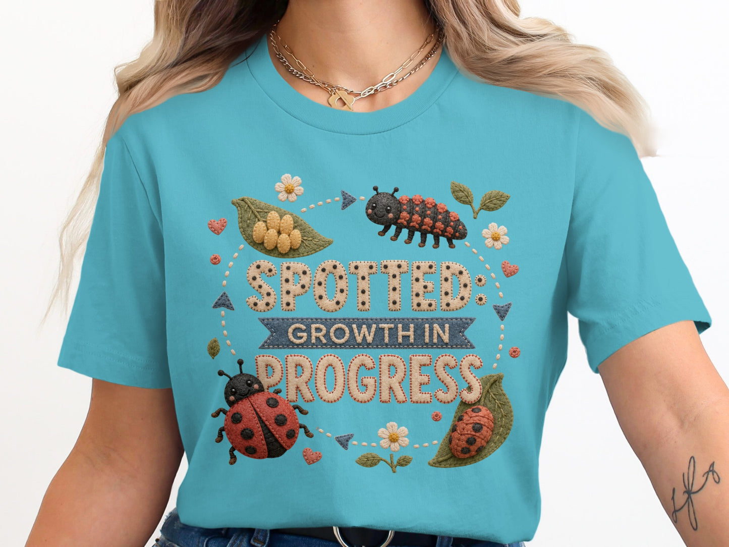 T-shirt with "Spotted: Growth in Progress" text and ladybug illustrations.