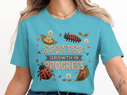 T-shirt with "Spotted: Growth in Progress" text and ladybug illustrations.
