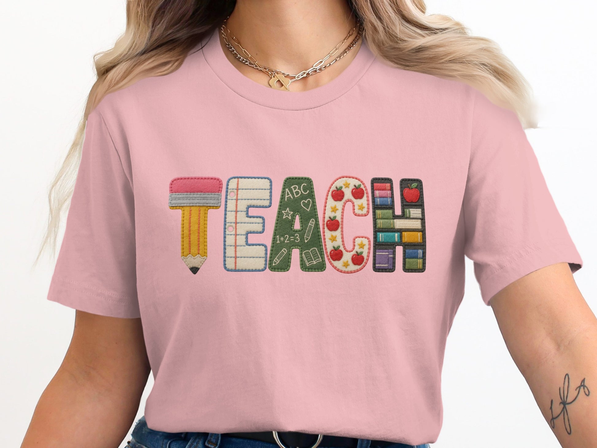 Pink t-shirt with the word TEACH designed with school-themed icons.