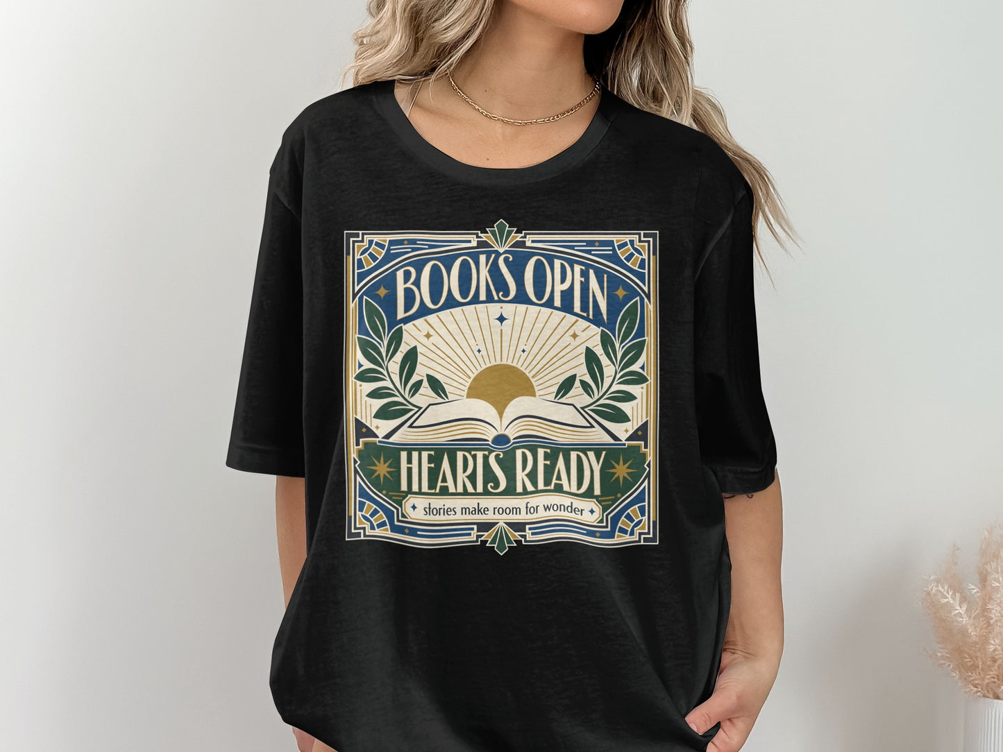 Black t-shirt with "BOOKS OPEN HEARTS READY stories make room for wonder" text and sun design.