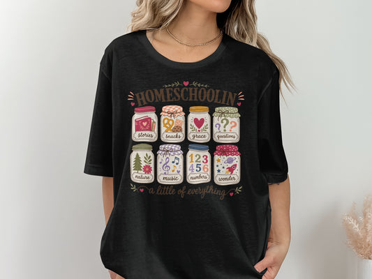Black t-shirt with "Homeschoolin' a little of everything" and eight labeled jars.