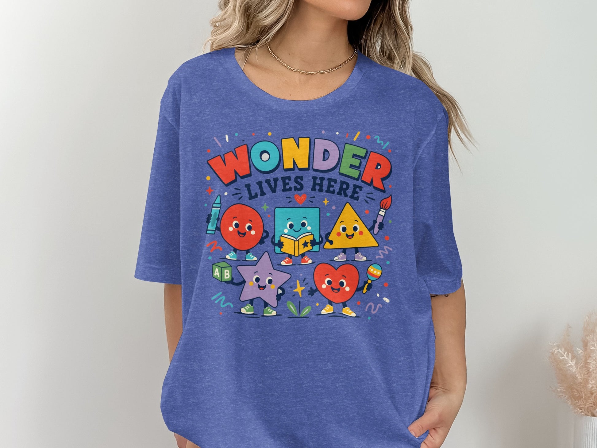 Graphic tee with "Wonder Lives Here" text and cartoon shapes: circle, square, triangle, star, heart.