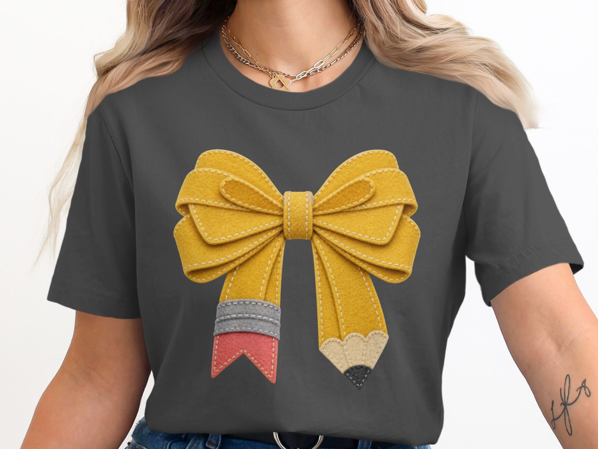 Yellow bow-shaped pencil on a dark gray t-shirt.