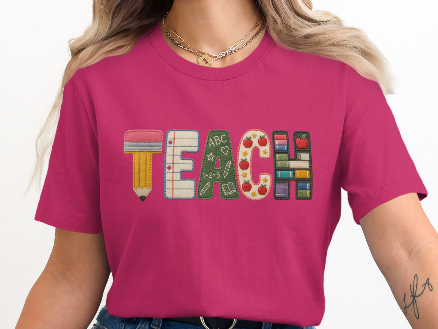 Fuchsia t-shirt with "TEACH" text made from school-themed applique letters.