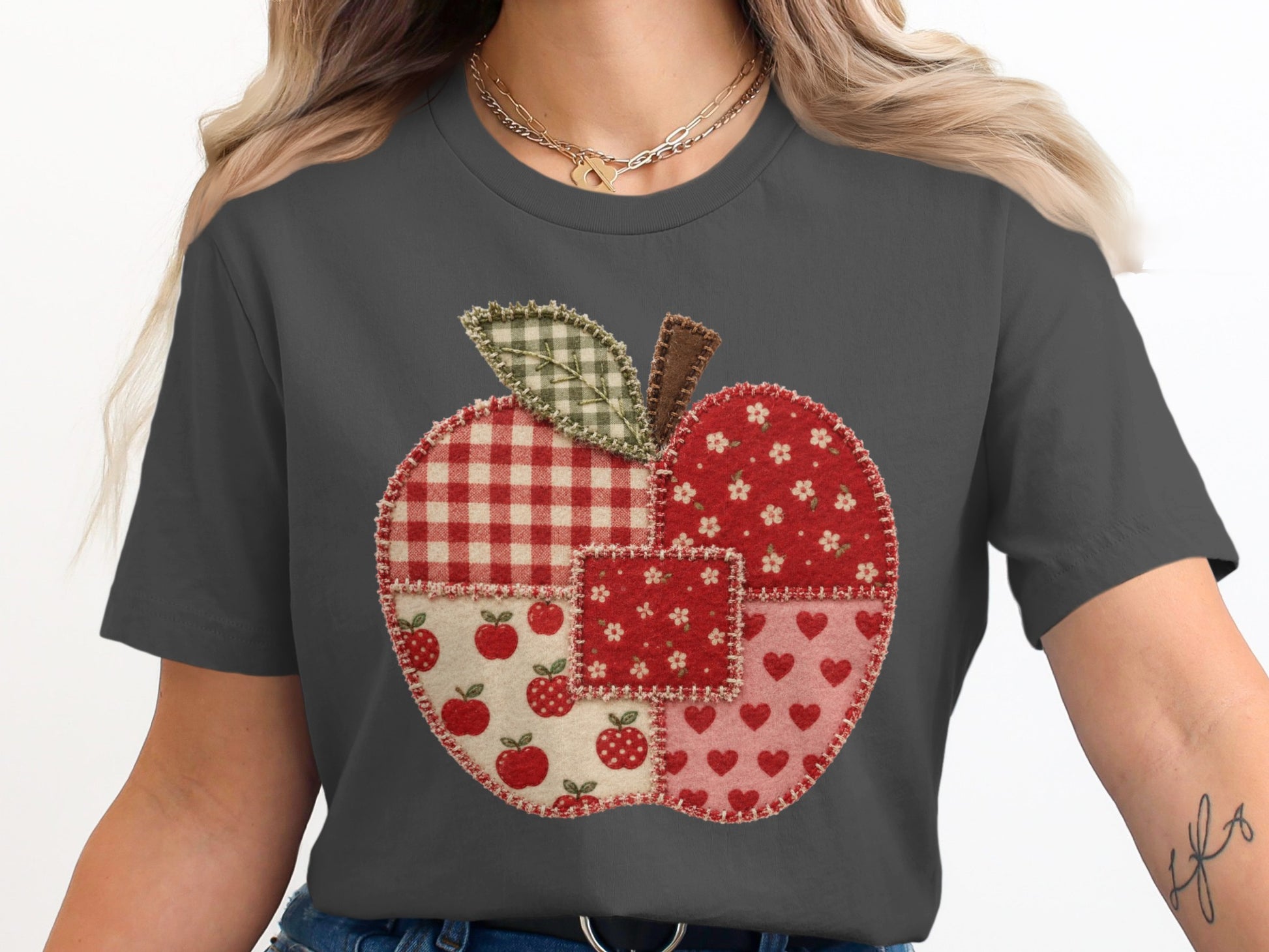 Appliqué apple made of patchwork fabrics on a dark gray t-shirt.