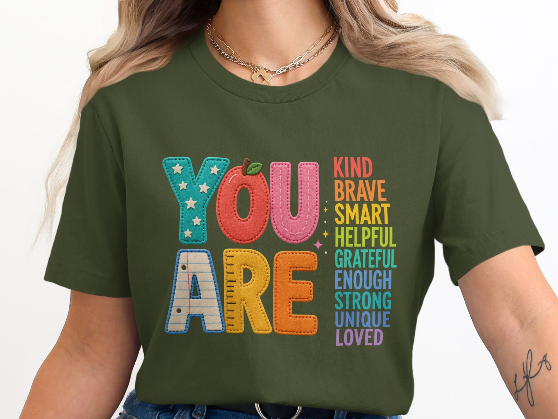 Green t-shirt with "YOU ARE" and positive affirmations in colorful block letters.