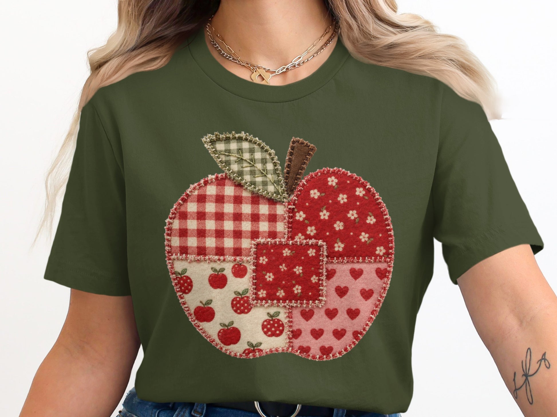 Green t-shirt with a patchwork apple design featuring red and white patterns.