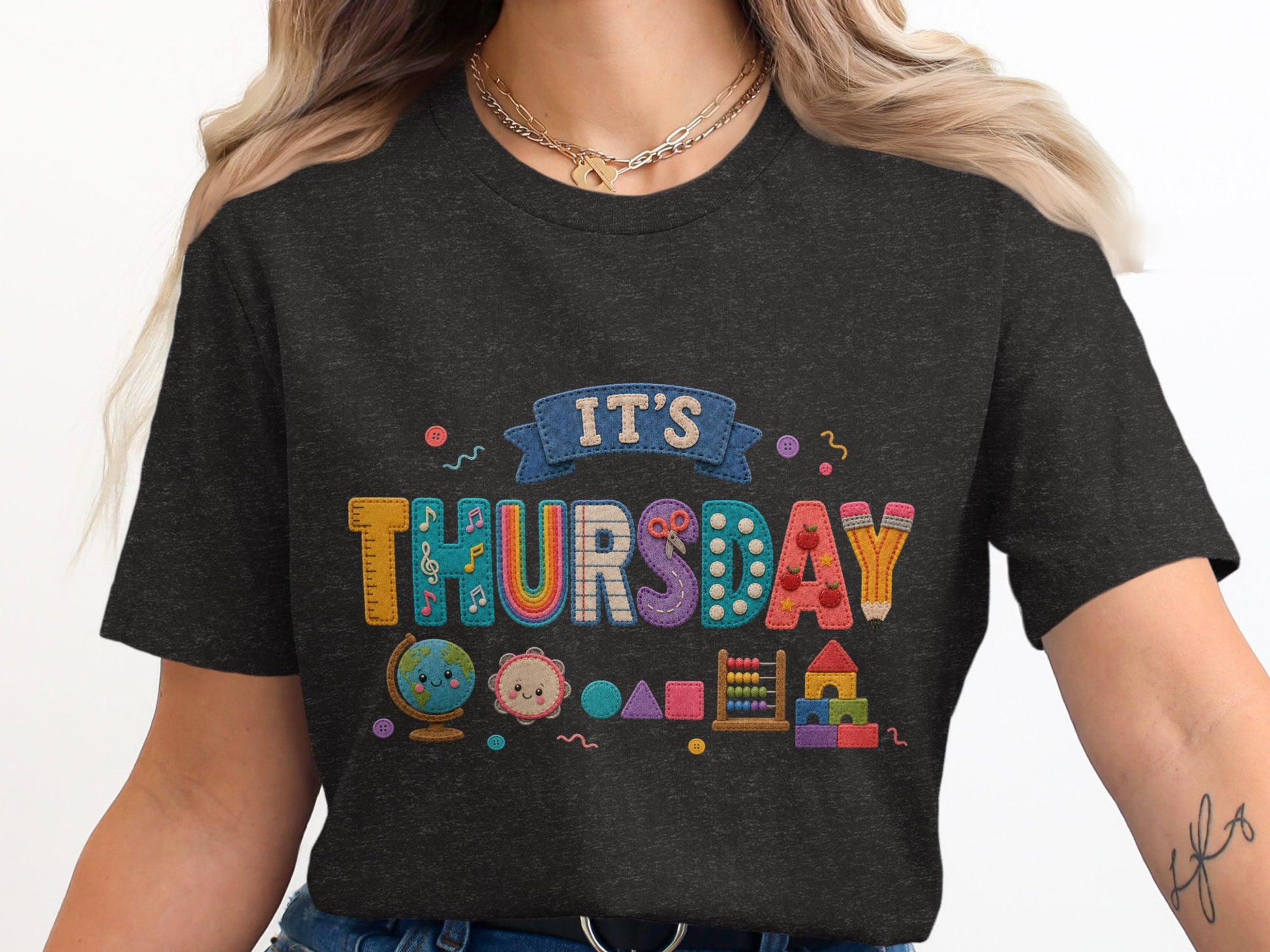 Dark t-shirt with "IT'S THURSDAY" text and colorful classroom graphics.