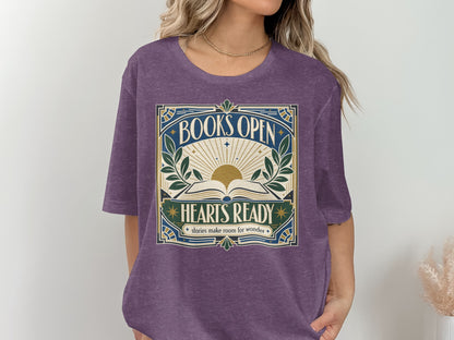 Purple t-shirt with a framed graphic featuring an open book, sun rays, leaves, and text.