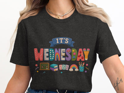 Children's t-shirt with colorful "It's Wednesday" graphic featuring school supplies and rainbows.