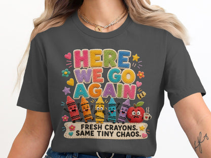 "Here We Go Again" shirt with crayons, apple, and text saying "Fresh Crayons. Same Tiny Chaos."