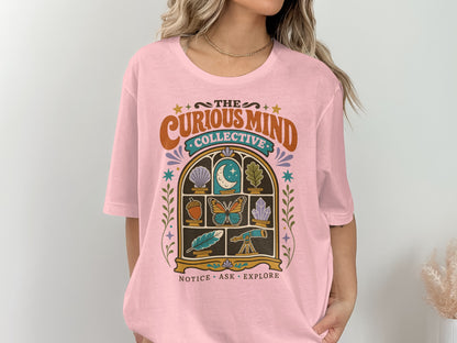 Pink t-shirt with retro graphic of "The Curious Mind Collective" and nature motifs.