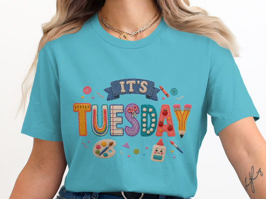 "It's Tuesday" text with school supplies on a teal t-shirt.