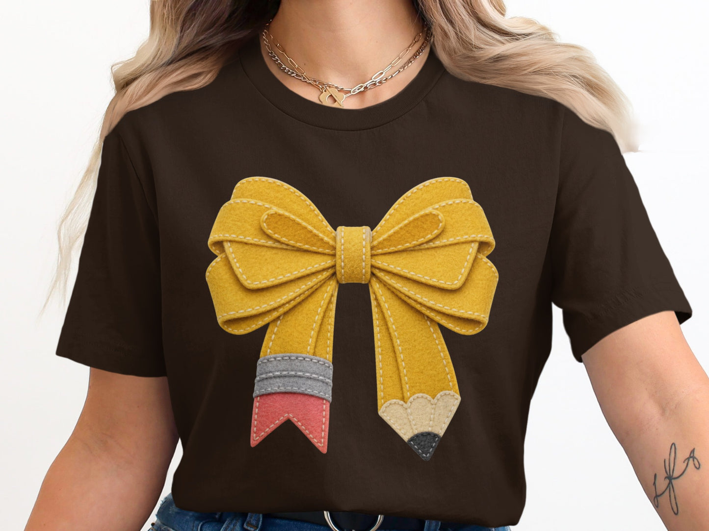 Brown t-shirt with a yellow felt bow designed to look like pencils.