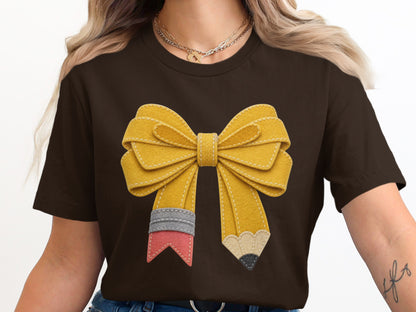 Brown t-shirt with a yellow felt bow designed to look like pencils.