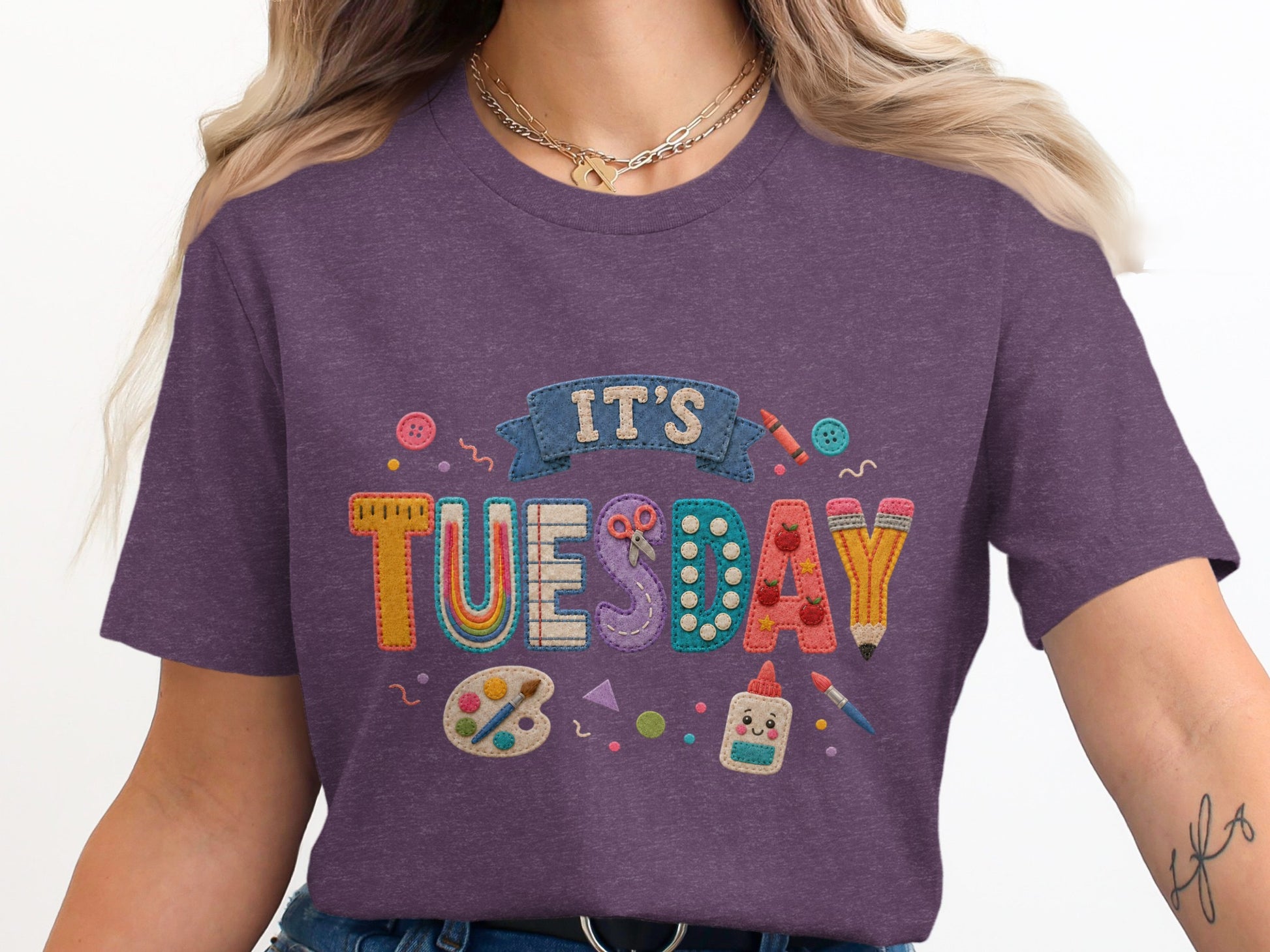 Purple t-shirt with "IT'S TUESDAY" text and art supplies graphics.
