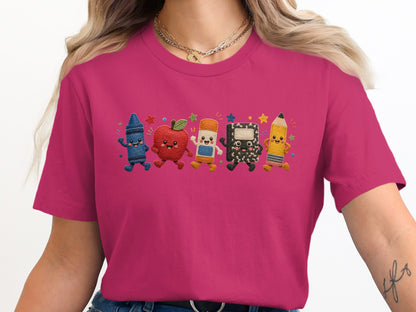 T-shirt with embroidered smiling school supplies: crayon, apple, eraser, notebook, and pencil.