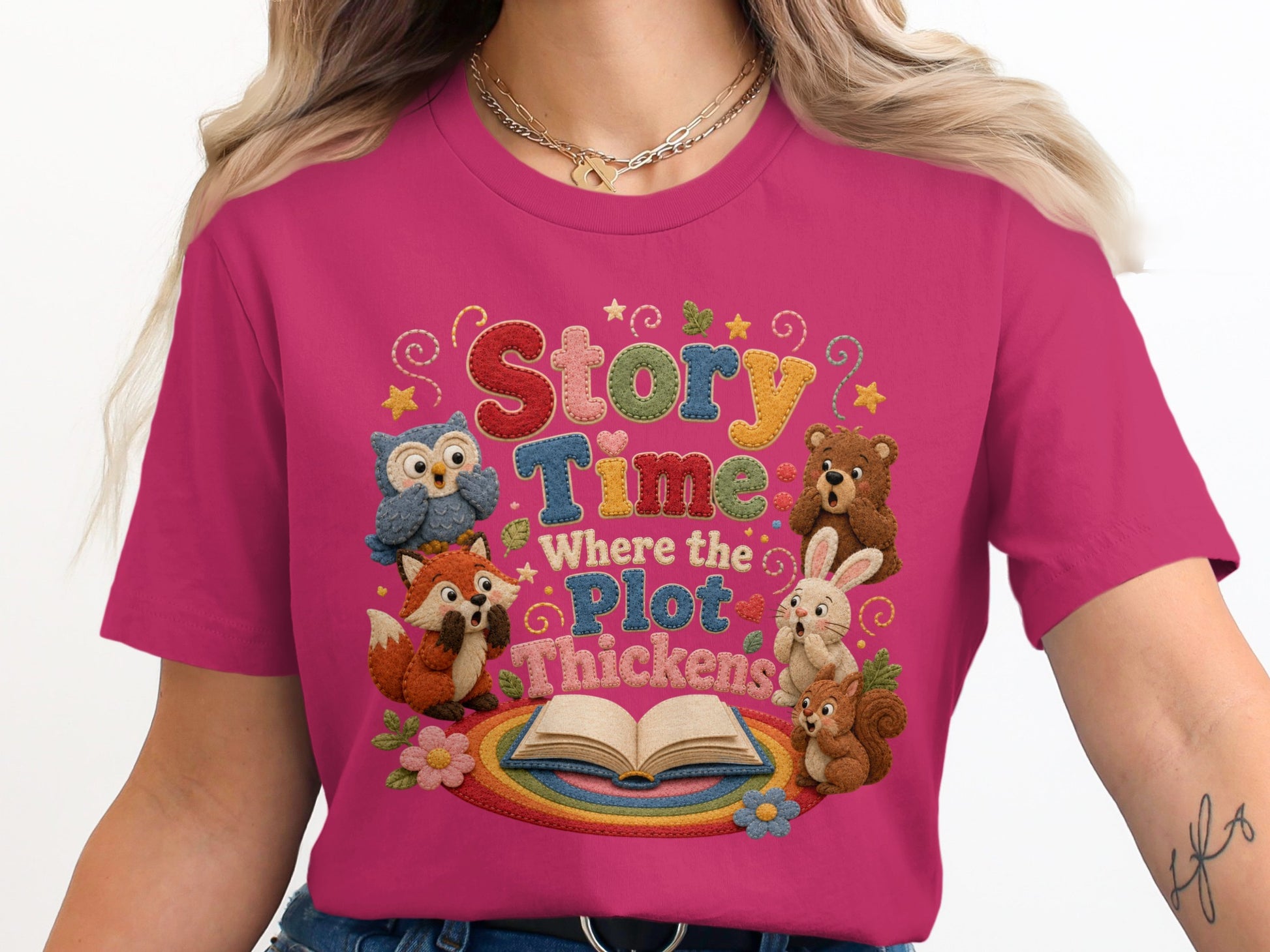 Pink t-shirt with embroidered "Story Time Where the Plot Thickens" and woodland creatures.