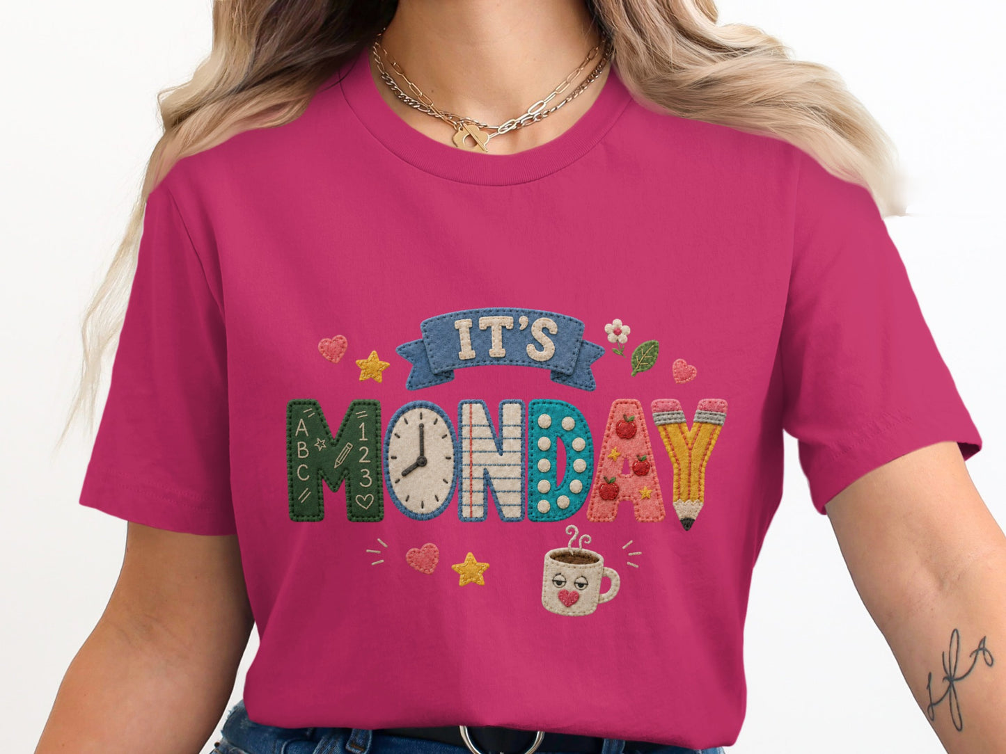 "IT'S MONDAY" graphic with school-themed letters, clock, and coffee cup on a pink shirt.