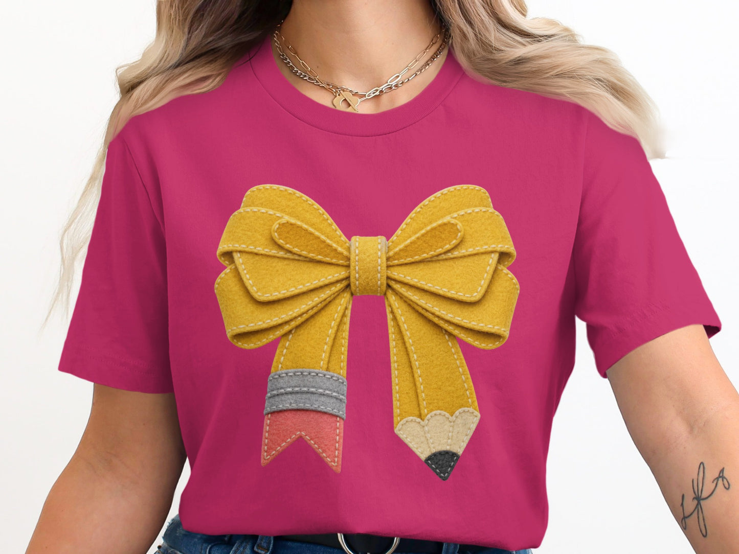 Pink t-shirt with a yellow pencil and bow graphic design.