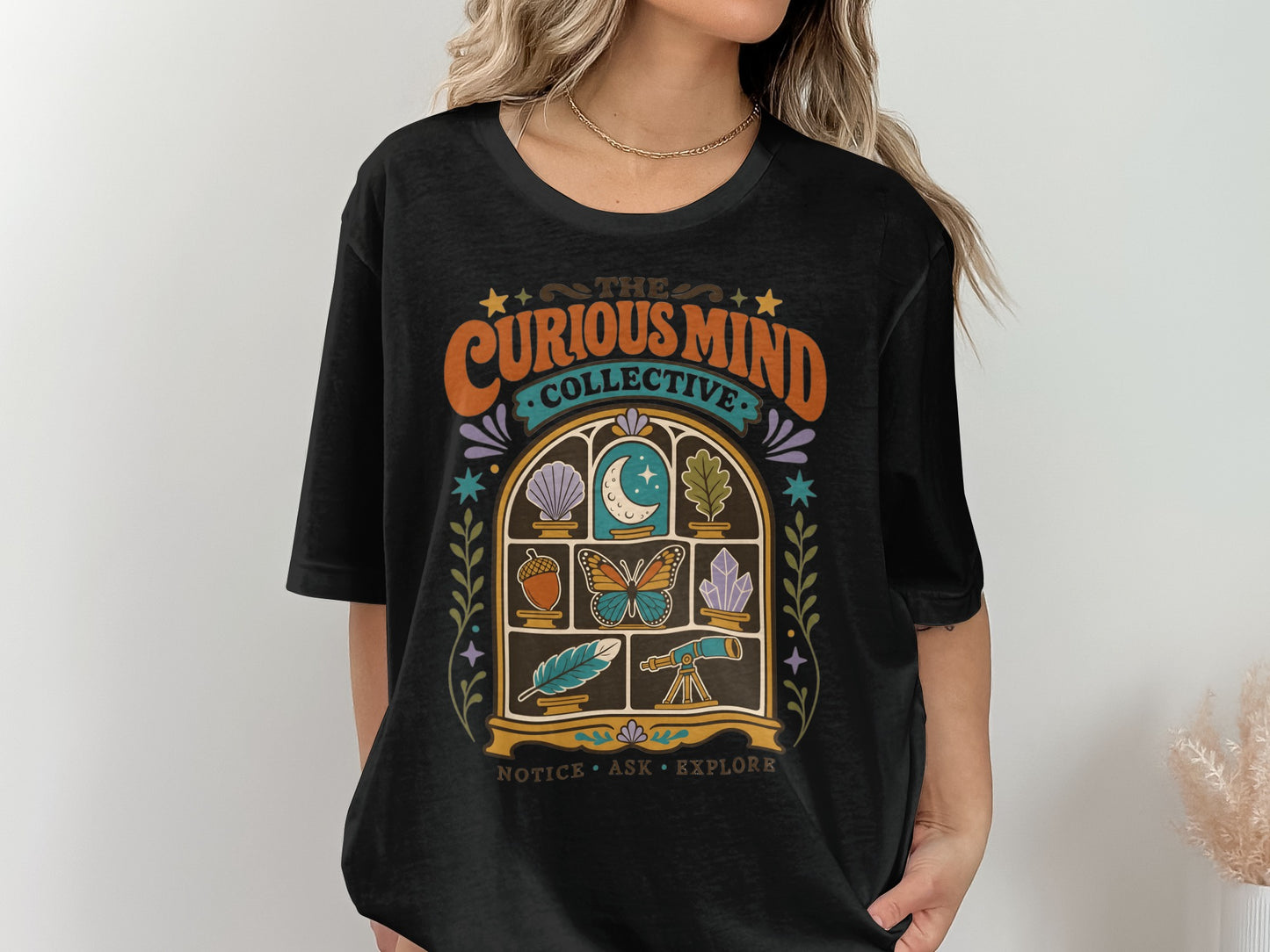 Black t-shirt with "The Curious Mind Collective" and window graphic featuring science icons.