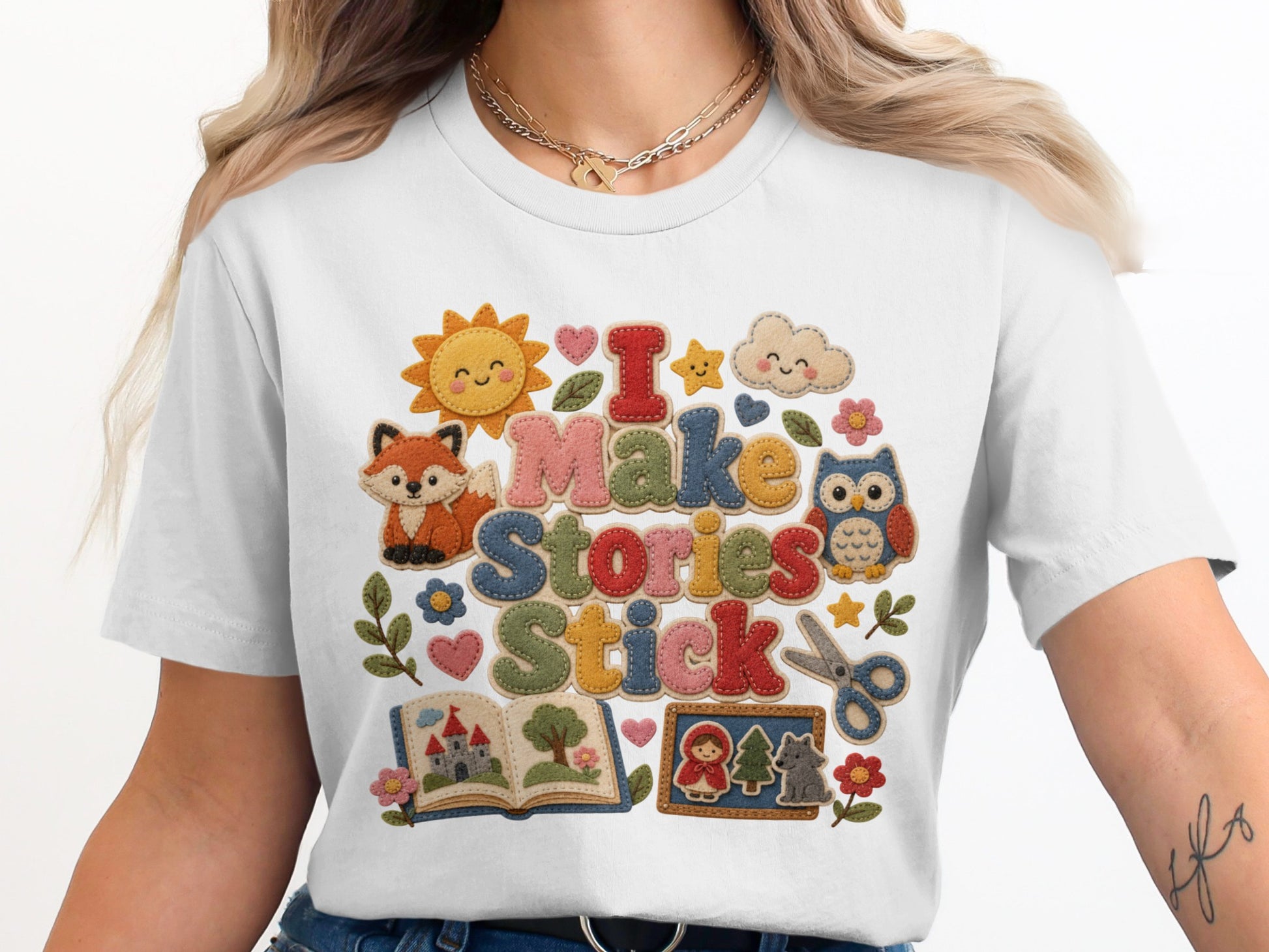 White t-shirt with "I Make Stories Stick" in felt letters and storybook graphics.