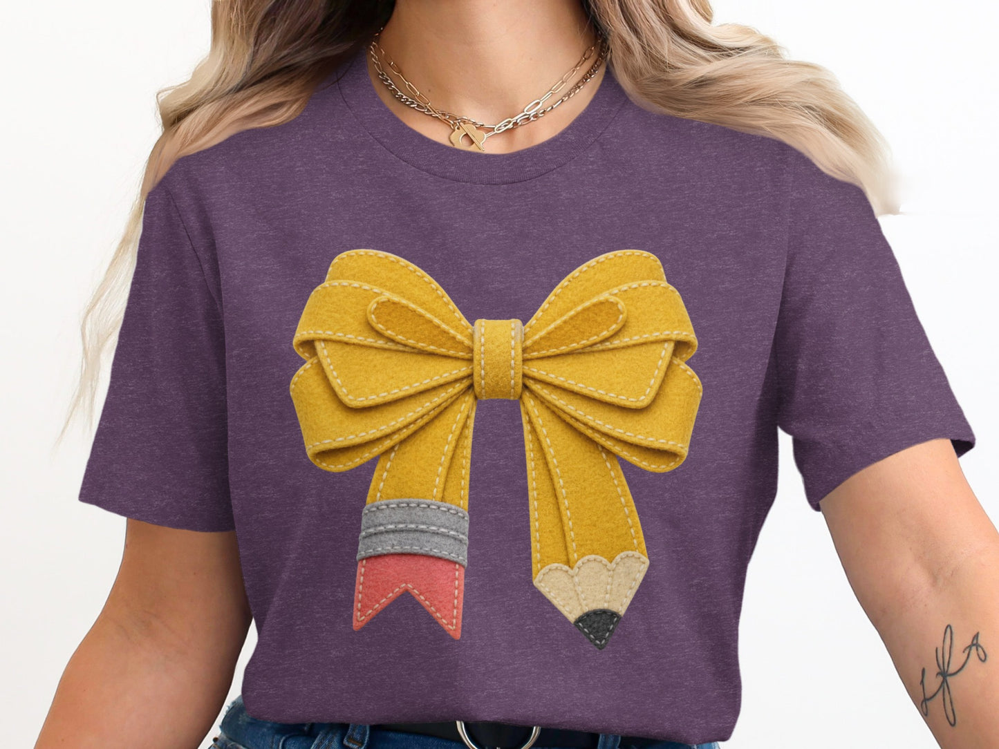 Purple t-shirt with a yellow pencil-shaped bow design