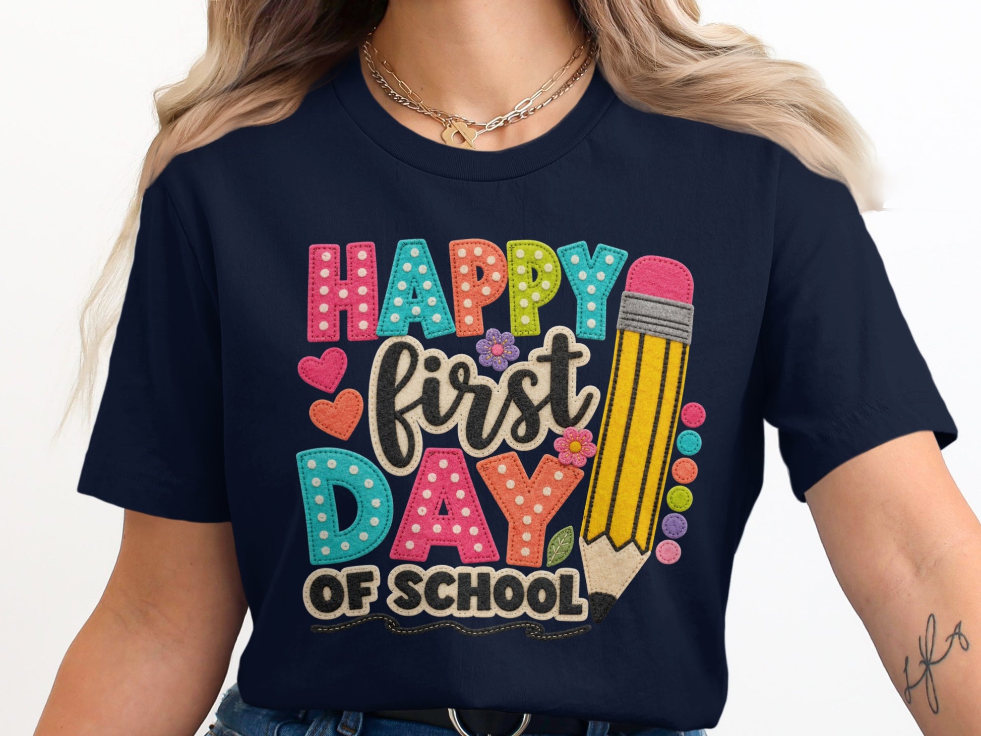 Happy first day of school text on a navy shirt with a pencil graphic.